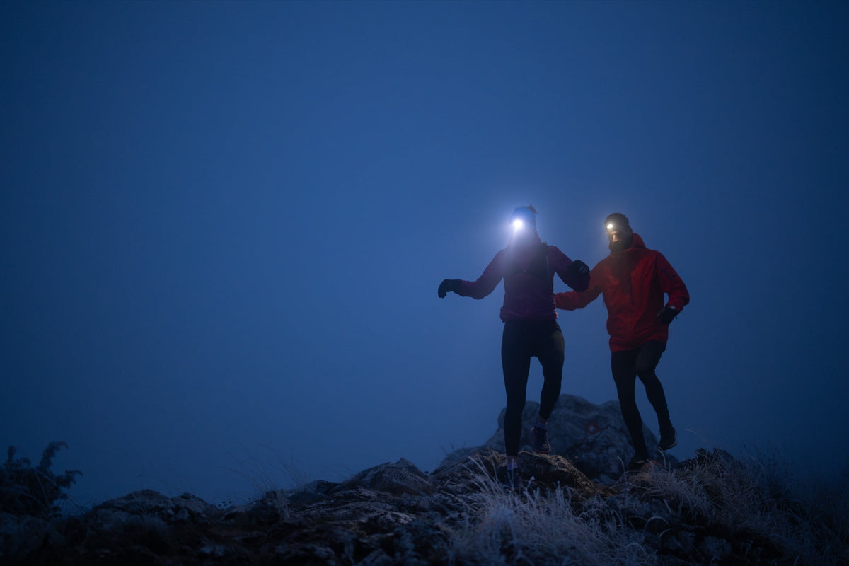Deux traileurs avec lampe frontale courant de nuit sur un sentier de montagne Image