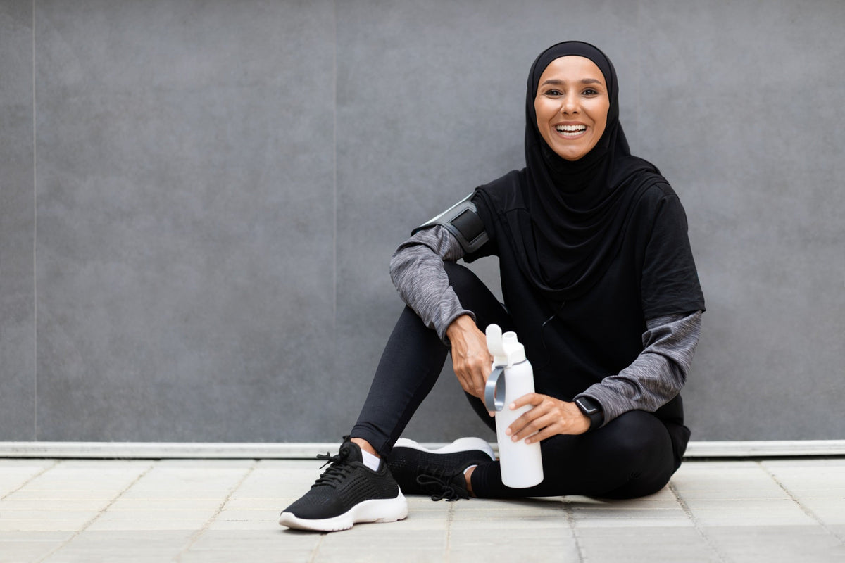 Sportive en hijab souriante avec sa gourde après l'entraînement Image